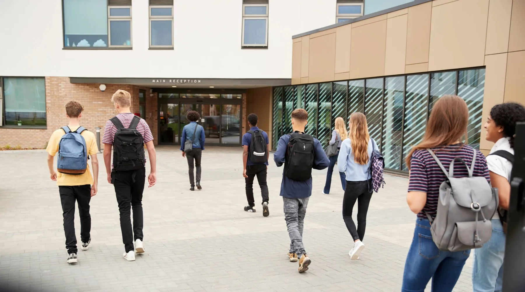 Students walking across a British school campus.