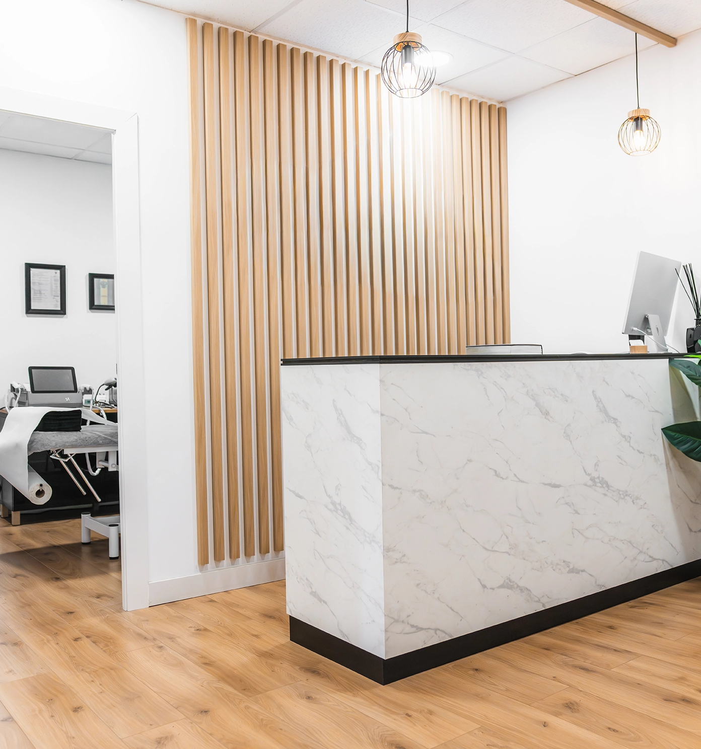 Modern clinic reception featuring a marble desk and wooden wall accents